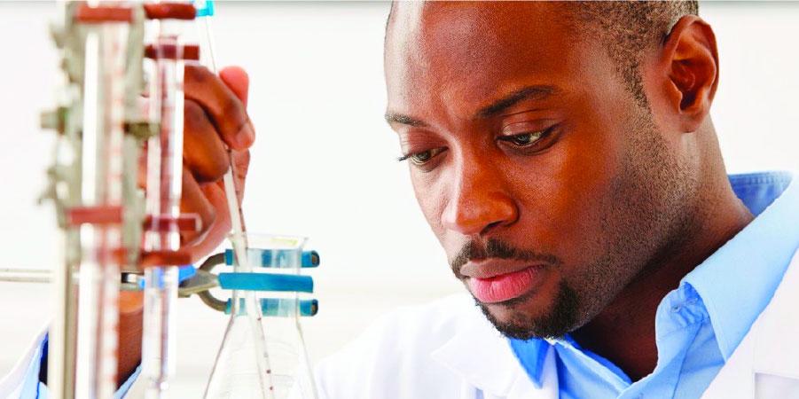 Closeup view of a researcher reading the temperature off a thermometer dipped into a beaker