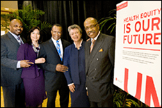 Group of 5 people pose next to a sign that reads "Health Equity, is our future"