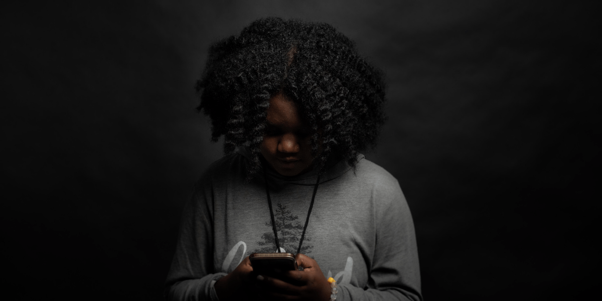 Black girl looking at smartphone