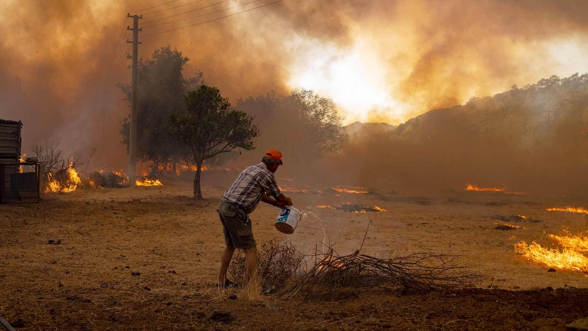 A man in rural Turkey tries to fight a wildfire in August 2021