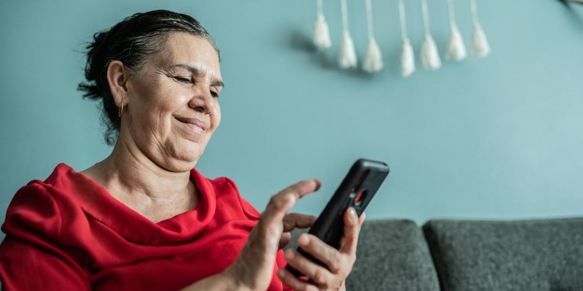 Elderly woman looks at phone